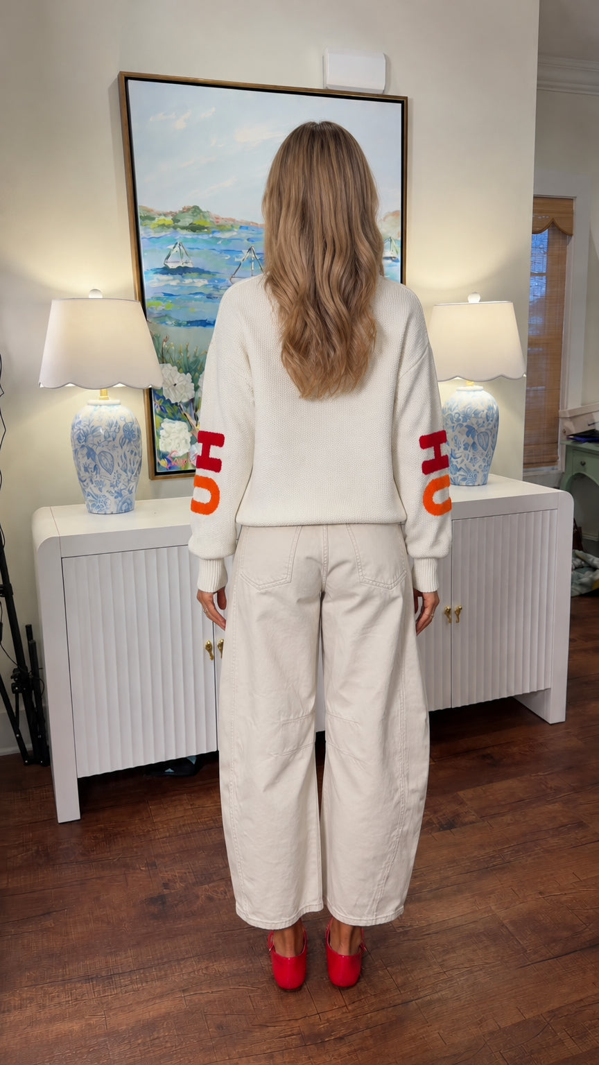 Back view of woman wearing relaxed white holiday knit pullover
