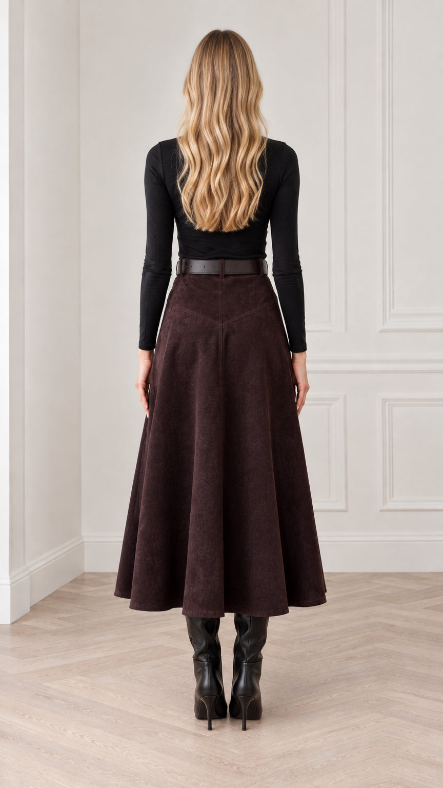 Back view of woman wearing dark brown high-waisted midi skirt with flared hem