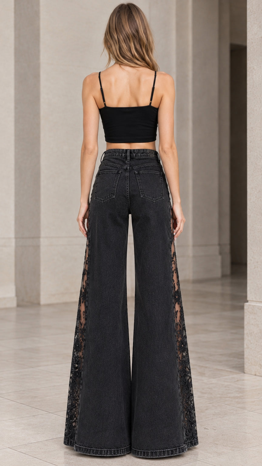 Back full-length view of model showcasing high-waisted fit and wide flare hem in washed black