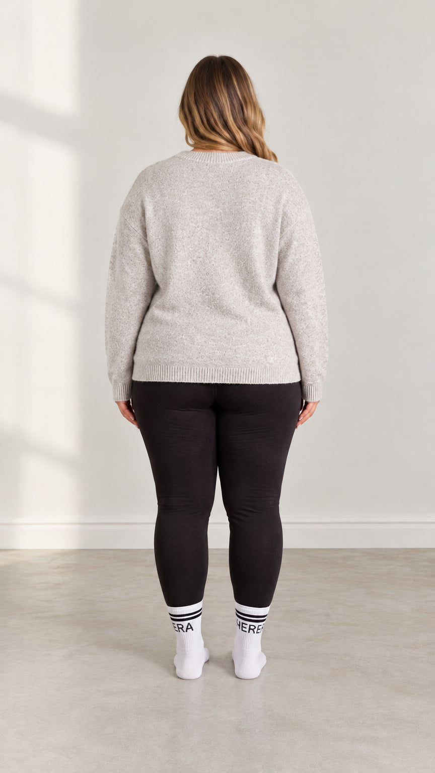 Back view of model wearing Light Grey plus size crewneck sweater