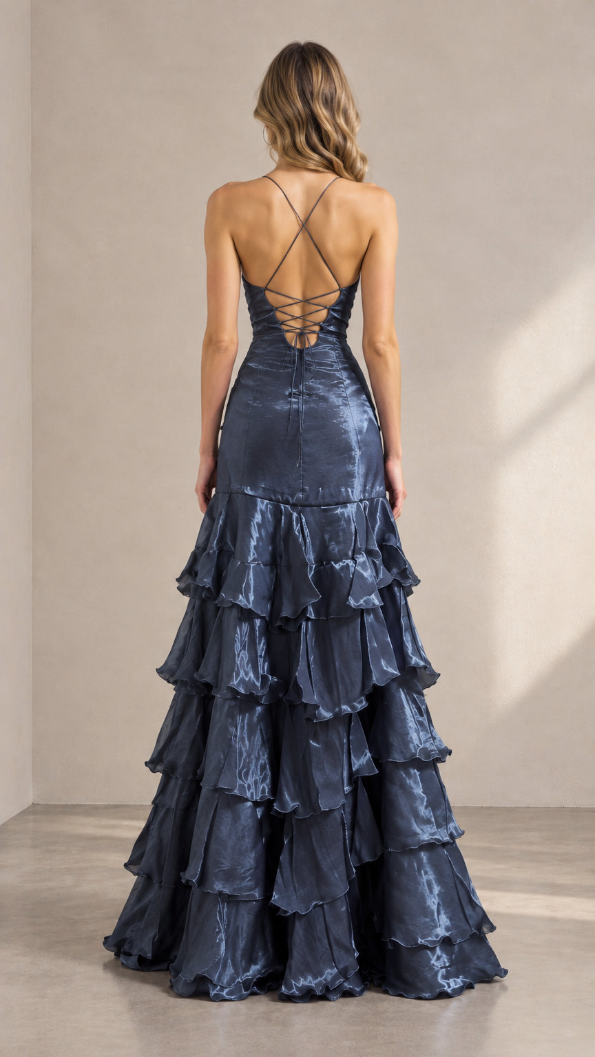 Back view of woman wearing slate blue evening gown displaying strappy crisscross lace-up open back