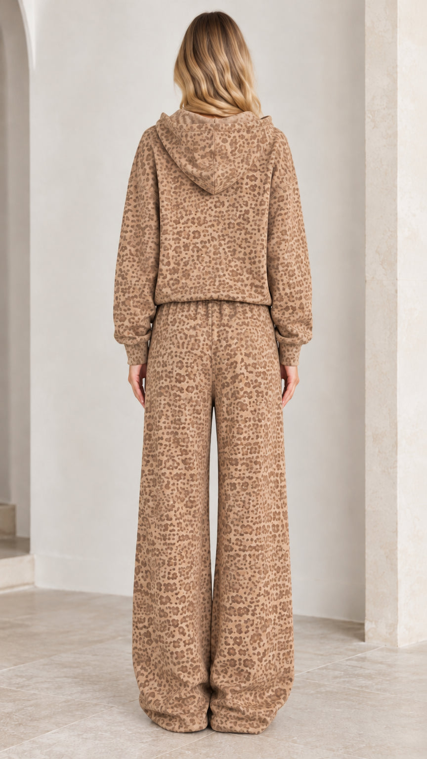 Back view of model wearing camel animal print hooded sweatshirt and wide-leg pants