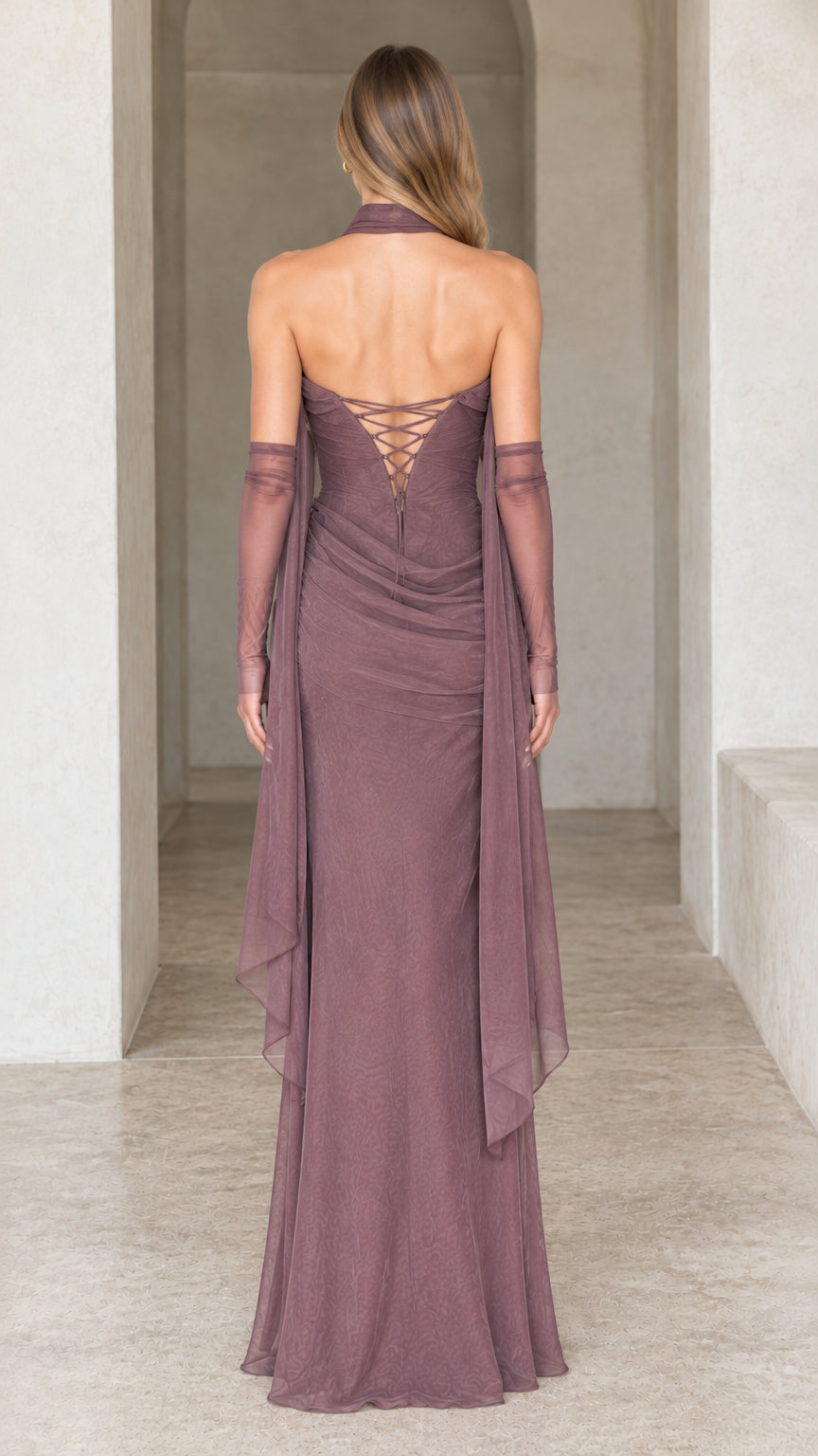 Rear view of dusty mauve gown highlighting the lace-up corset back and trailing scarf detail
