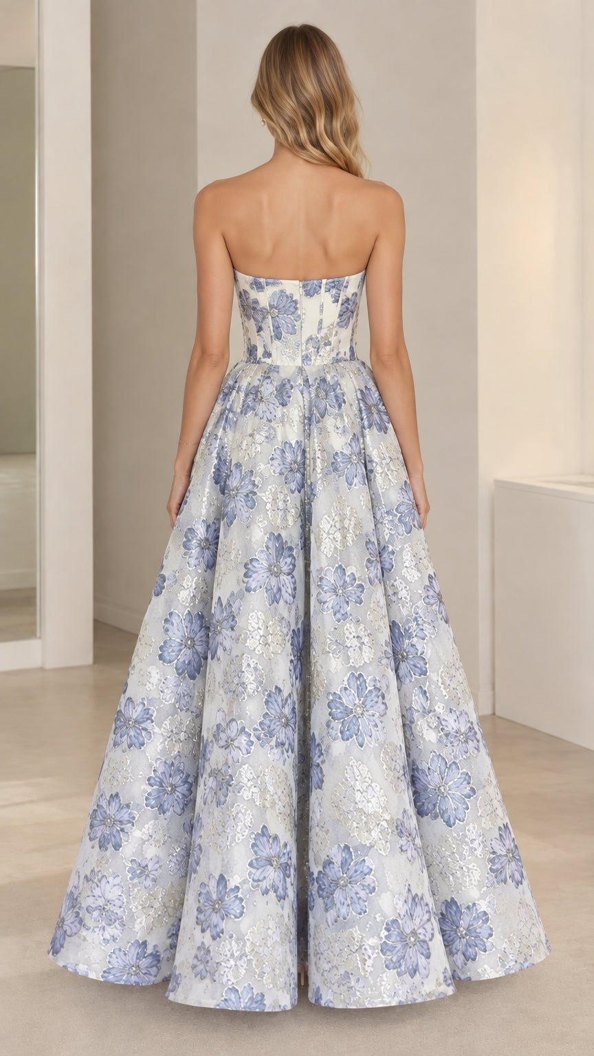 Back view of model showing strapless back and flowing skirt of blue jacquard gown