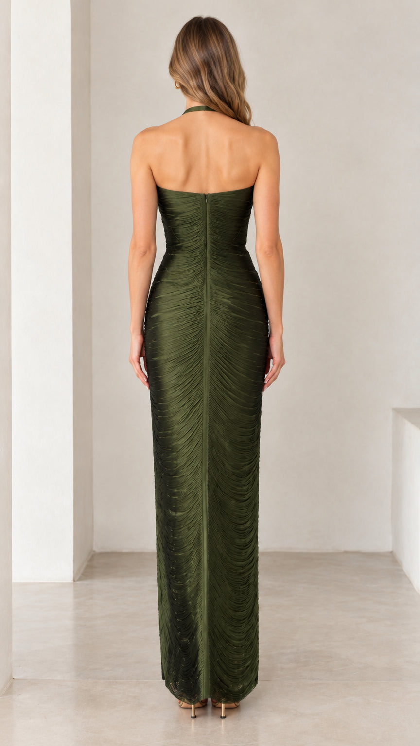 Back view of woman showcasing open back and zip closure on olive green maxi dress