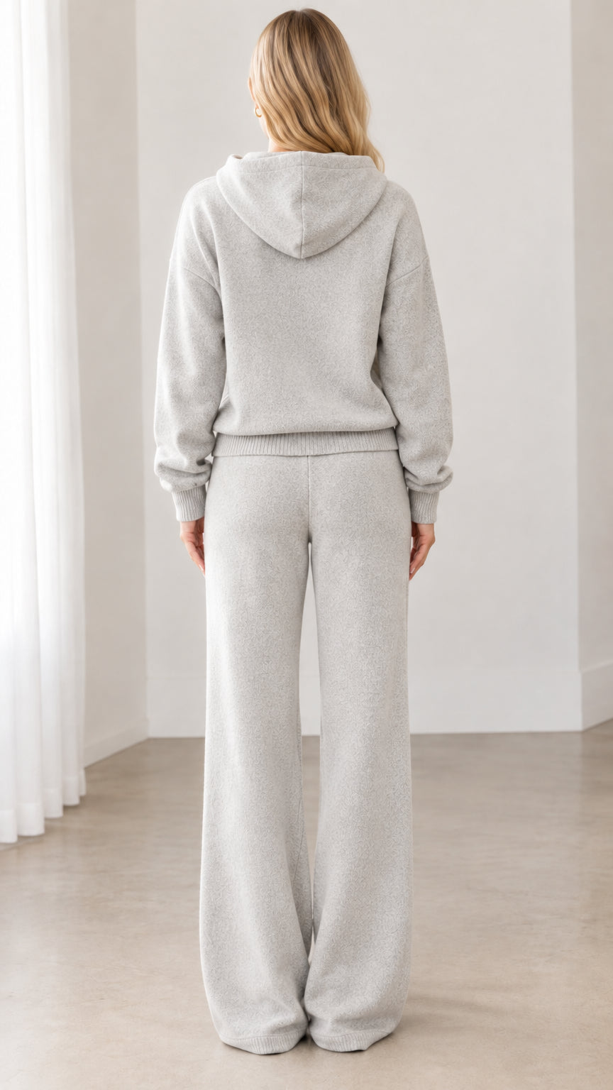 Back view of model wearing heather gray fleece hoodie and matching wide-leg lounge pants