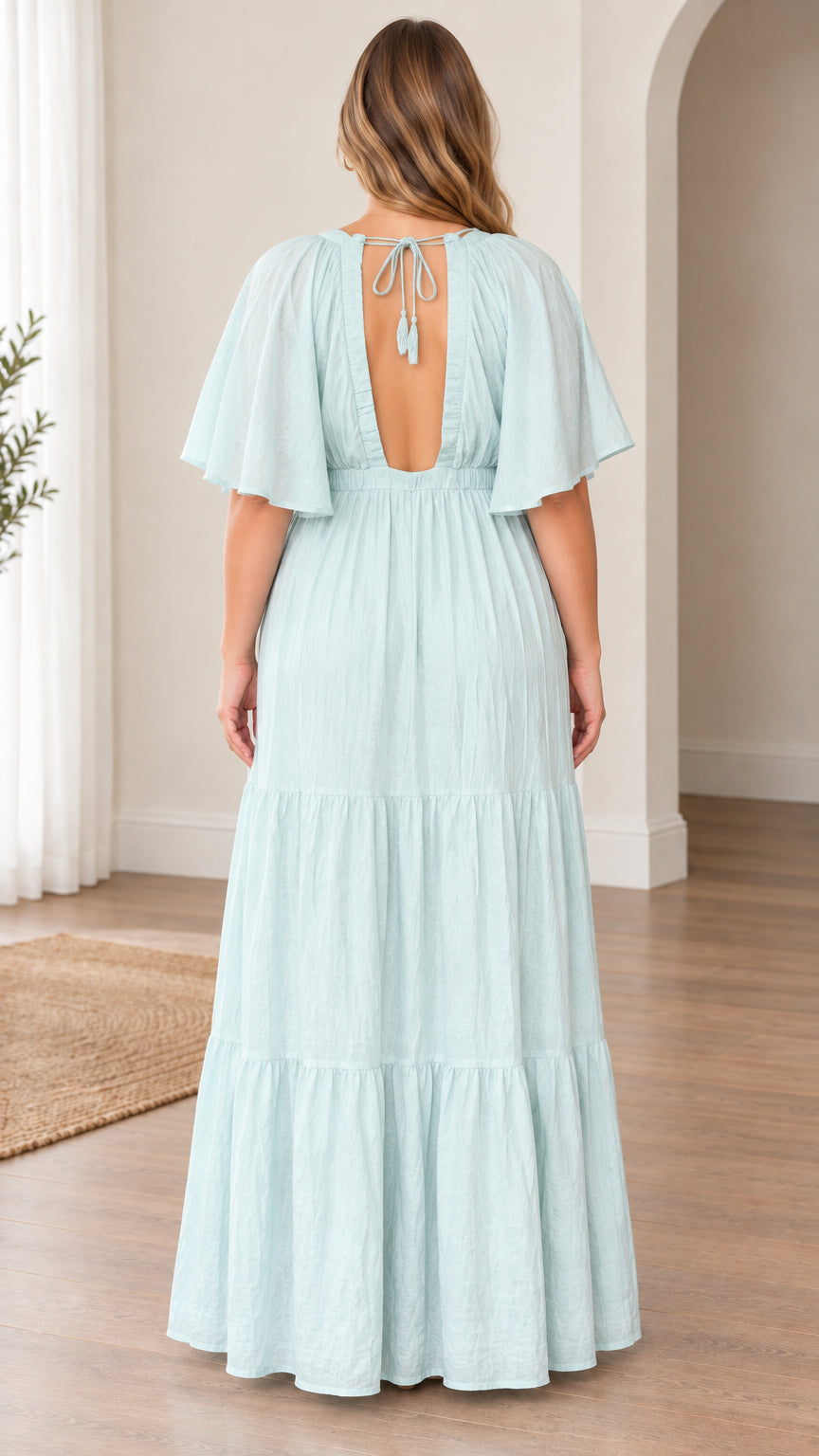 Back view of model showing open back cutout with tassel tie closure on light blue maxi dress