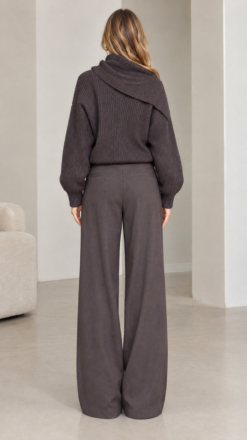 Back view of model wearing charcoal grey ribbed knit sweater showing relaxed fit and back collar drape