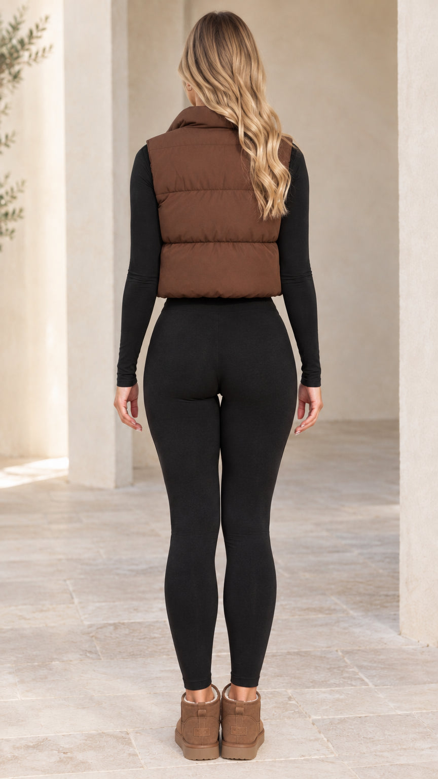 Back view of woman wearing brown quilted cropped puffer vest