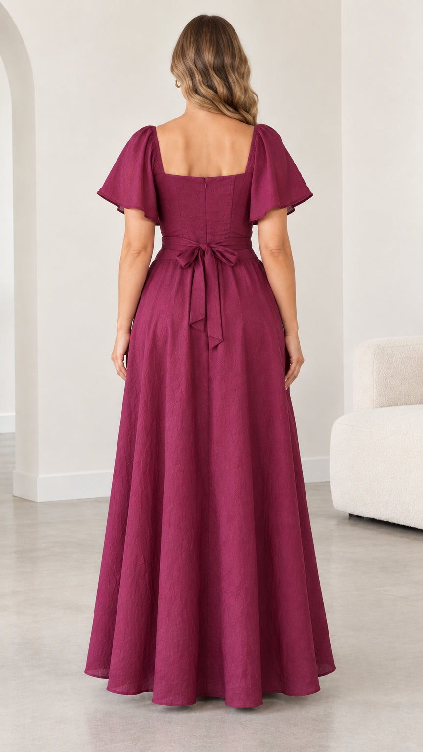 Back view of woman wearing magenta maxi dress showing square back and tied waist sash
