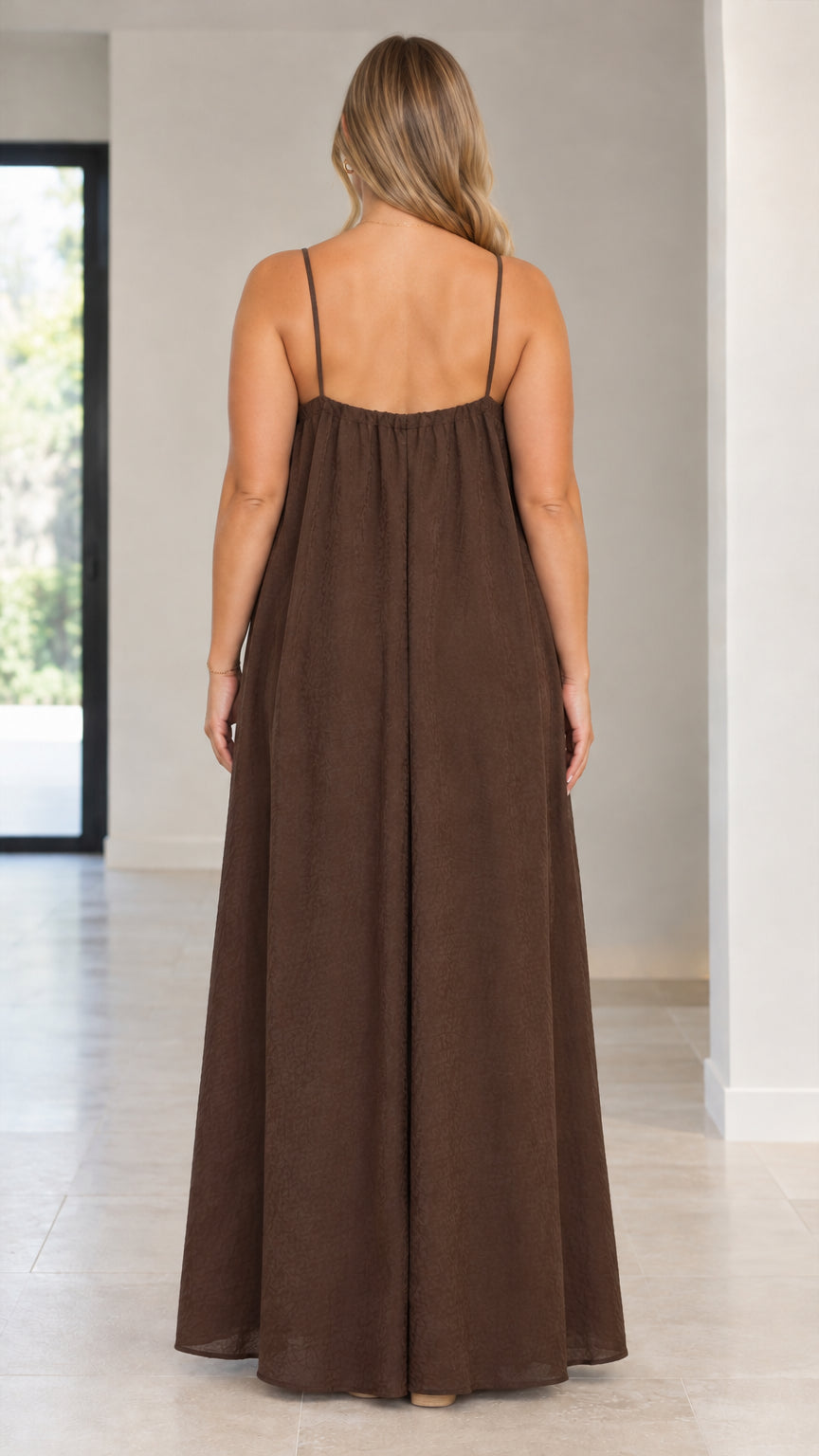 Back view of model wearing a brown spaghetti strap jumpsuit with wide palazzo legs