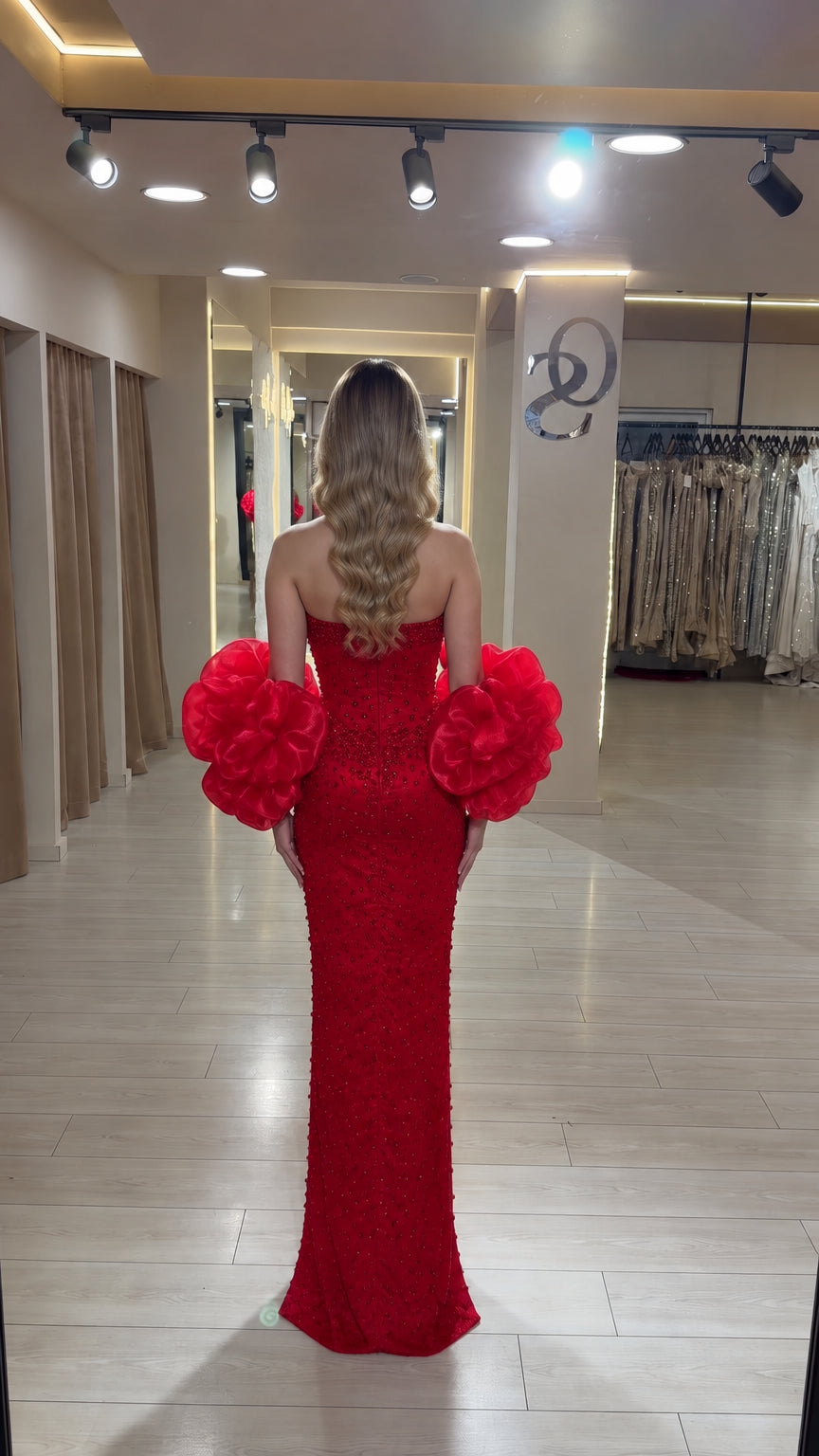 Back view of the red floor-length sequin evening gown with statement sleeves