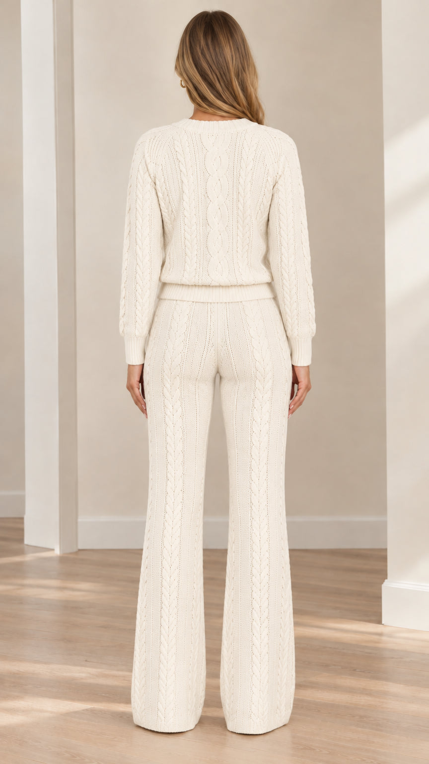 Back full view of woman wearing cream cable knit pullover and wide flare pants
