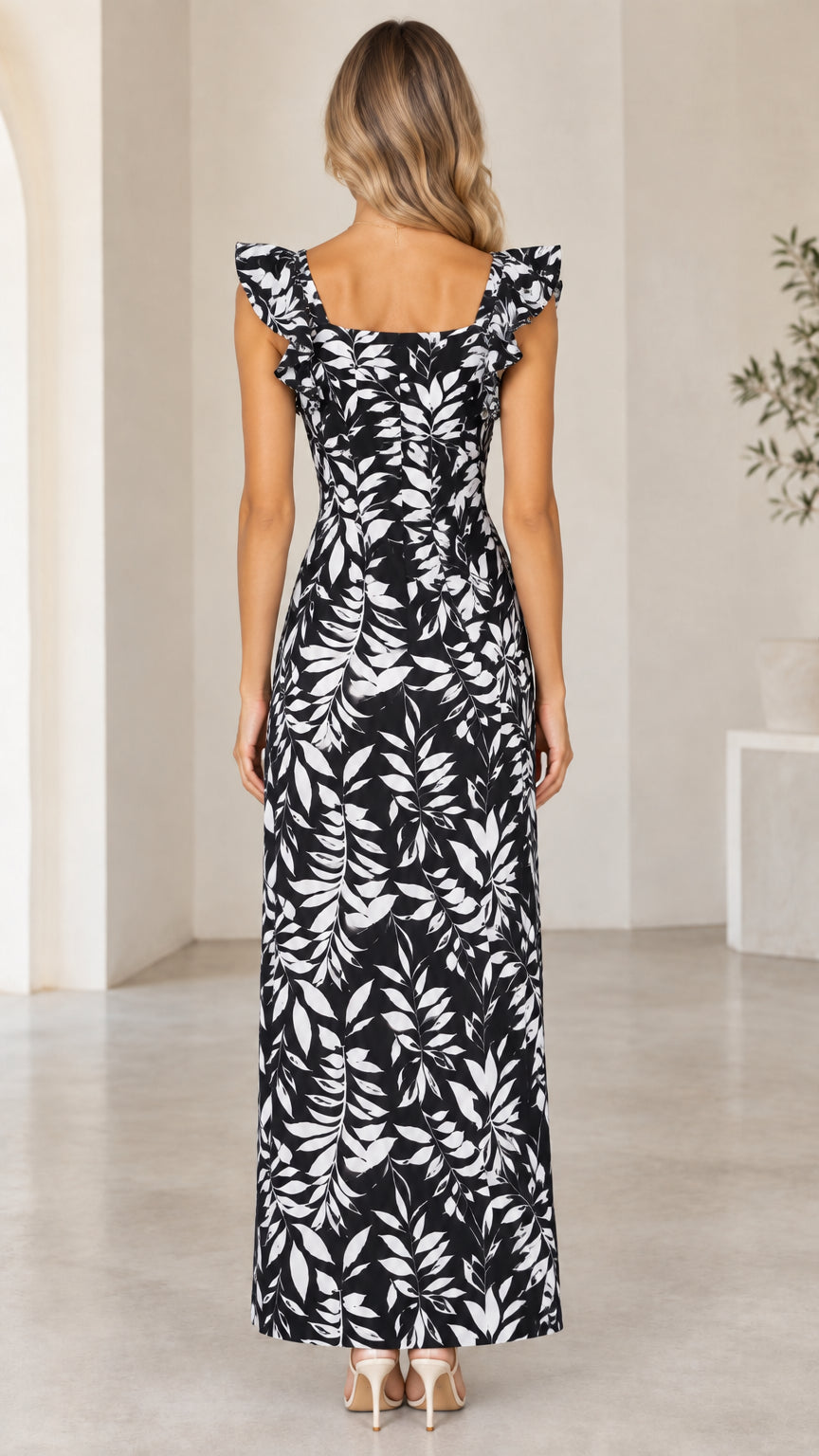Back view of model wearing black and white leaf print maxi dress with square back