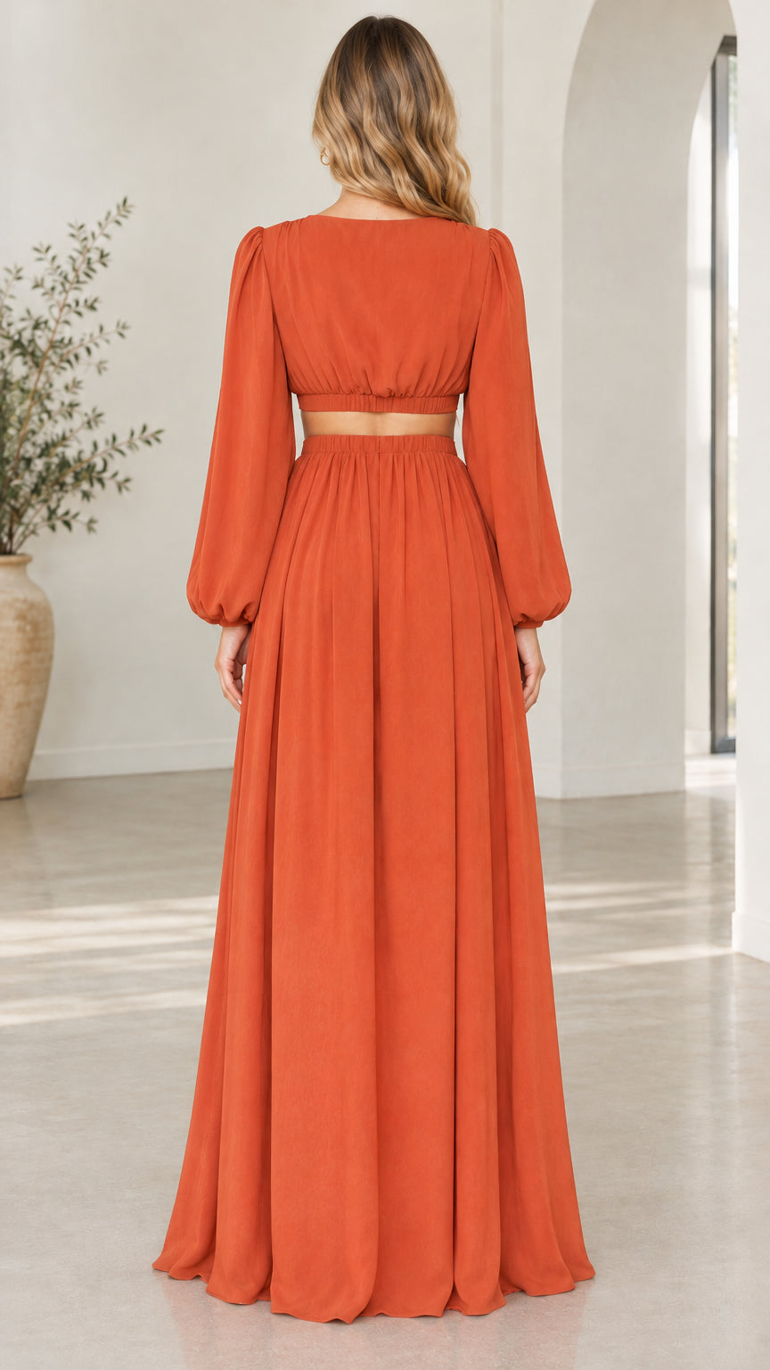 Back view of woman wearing rust orange cutout maxi dress with balloon sleeves