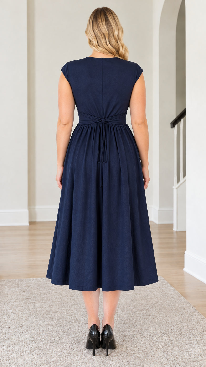 Back view of model wearing Navy Blue midi dress highlighting back waist tie detail