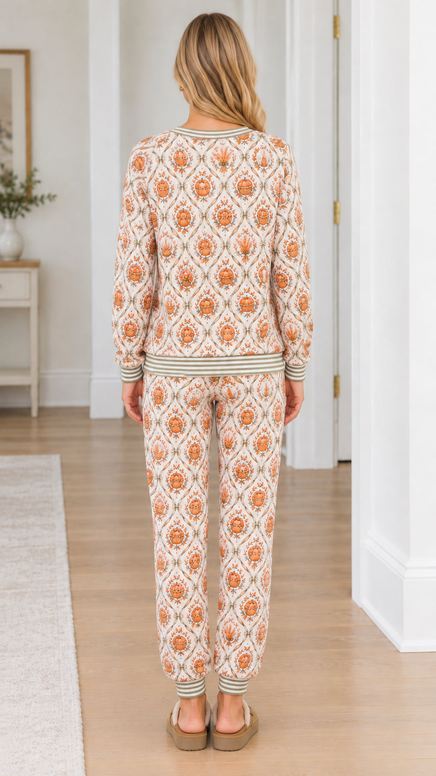 Back view of model showcasing matching cream pumpkin print crewneck and jogger pants