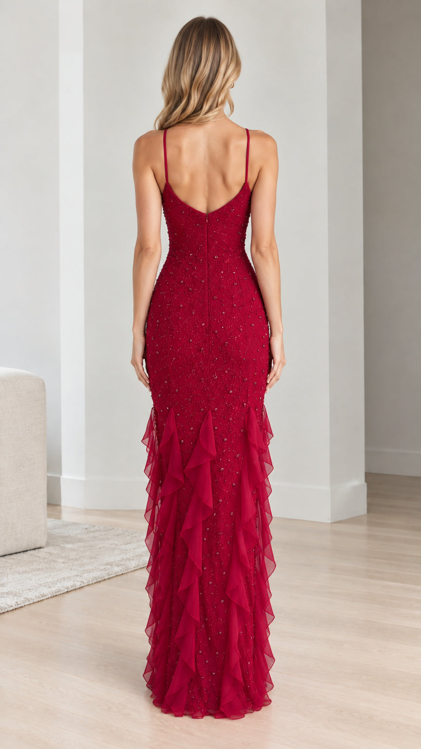 Back view of model showcasing the low back and ruffled hem of ruby red evening gown