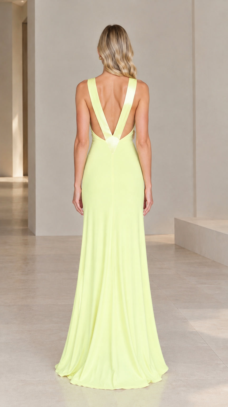 Back view of model wearing yellow evening gown highlighting low open V-back design