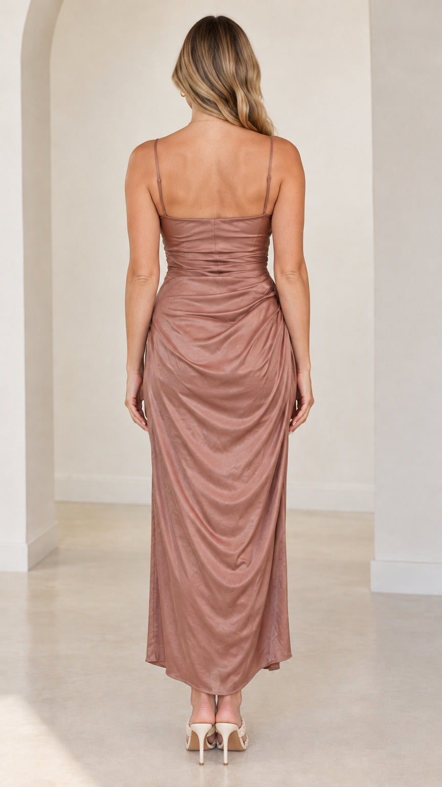 Back view of woman wearing dusty rose spaghetti strap satin midi dress