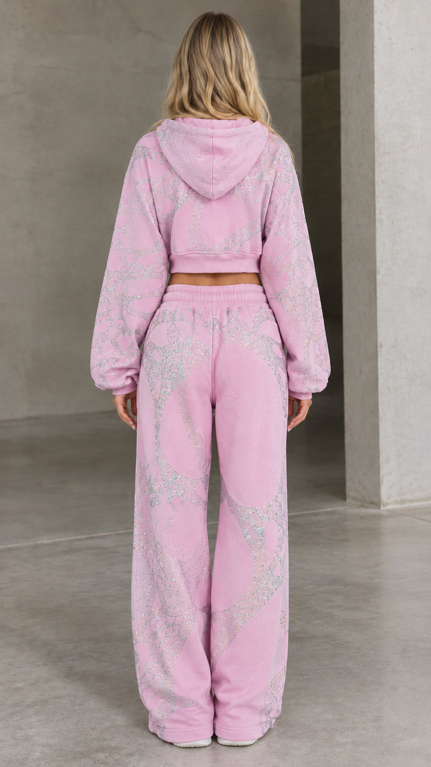 Back view of woman wearing pink cropped zip hoodie and matching wide-leg lounge pants