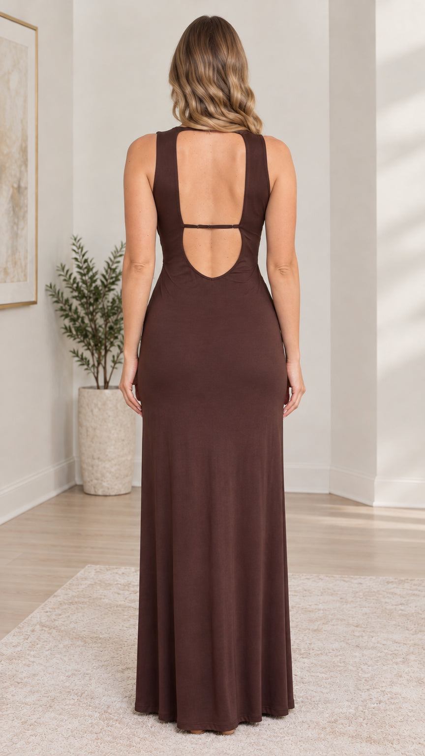 Back view of model showing open cutout back and strap detail on brown maxi dress