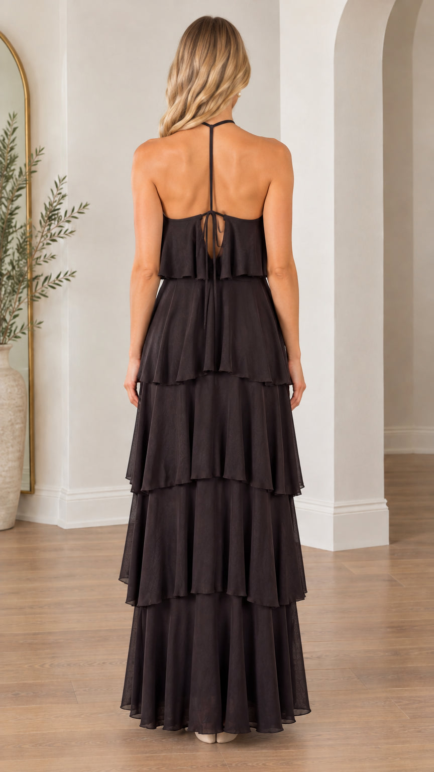 Back view of model wearing black halter maxi dress with open back and tie closure