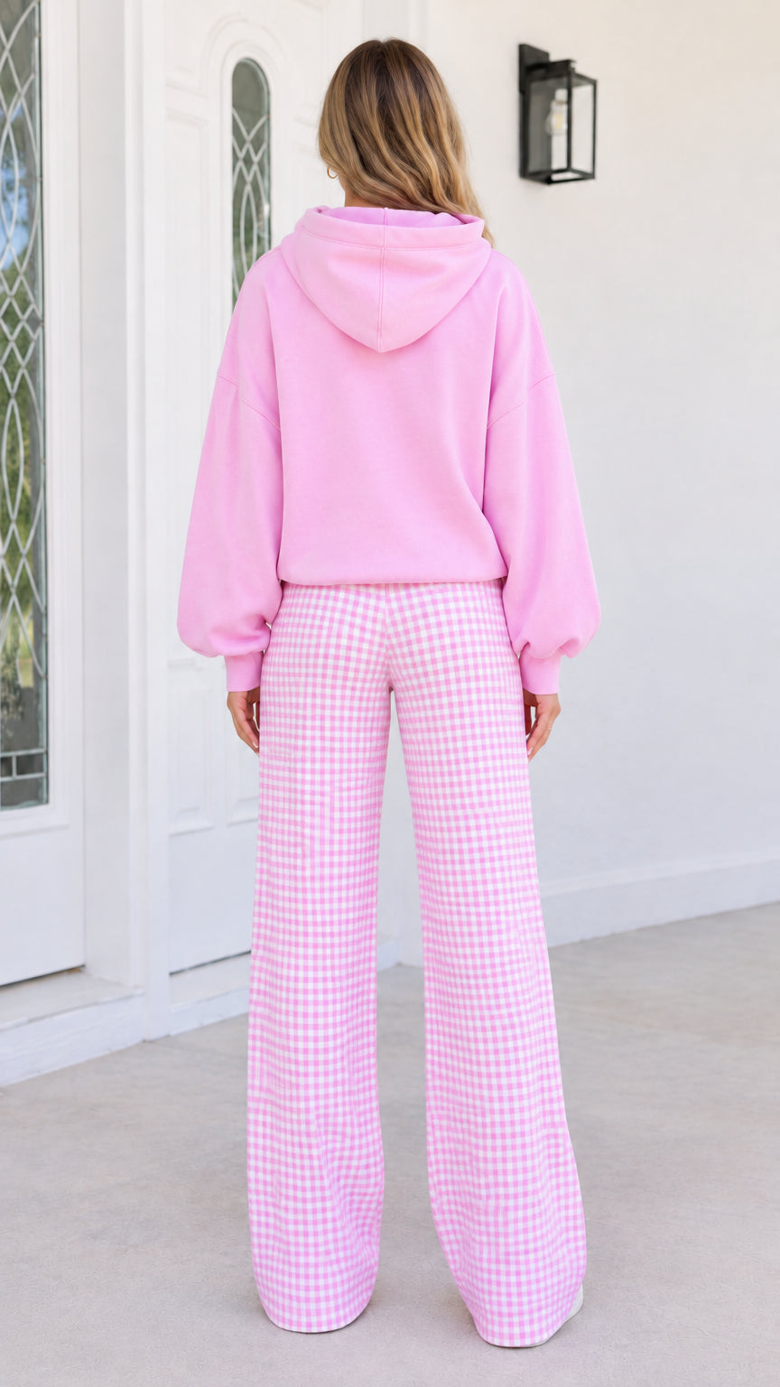 Back view of woman wearing pink oversized hoodie and pink gingham wide-leg pants