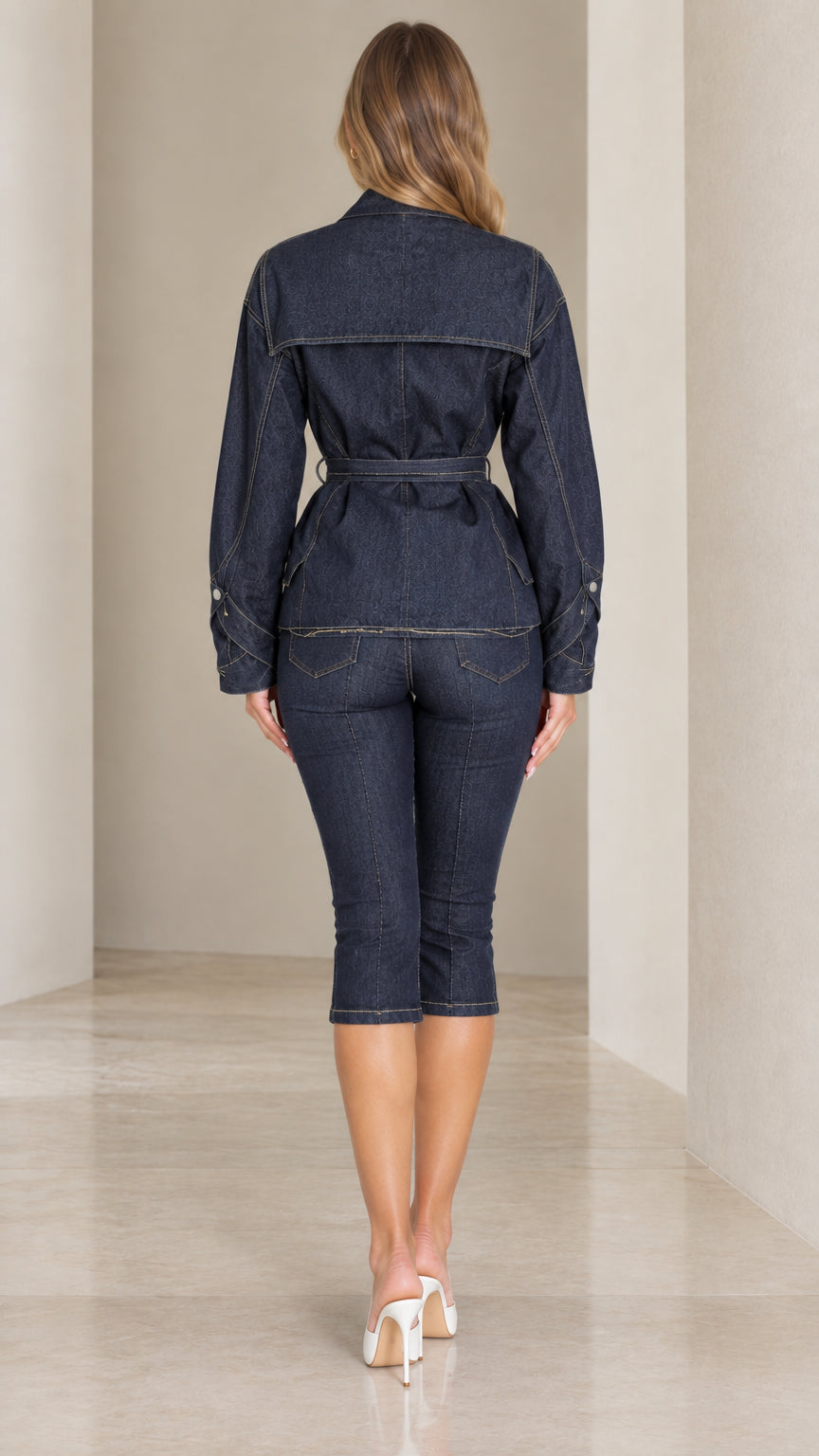 Back view of woman wearing dark blue belted denim jacket and capri pants set