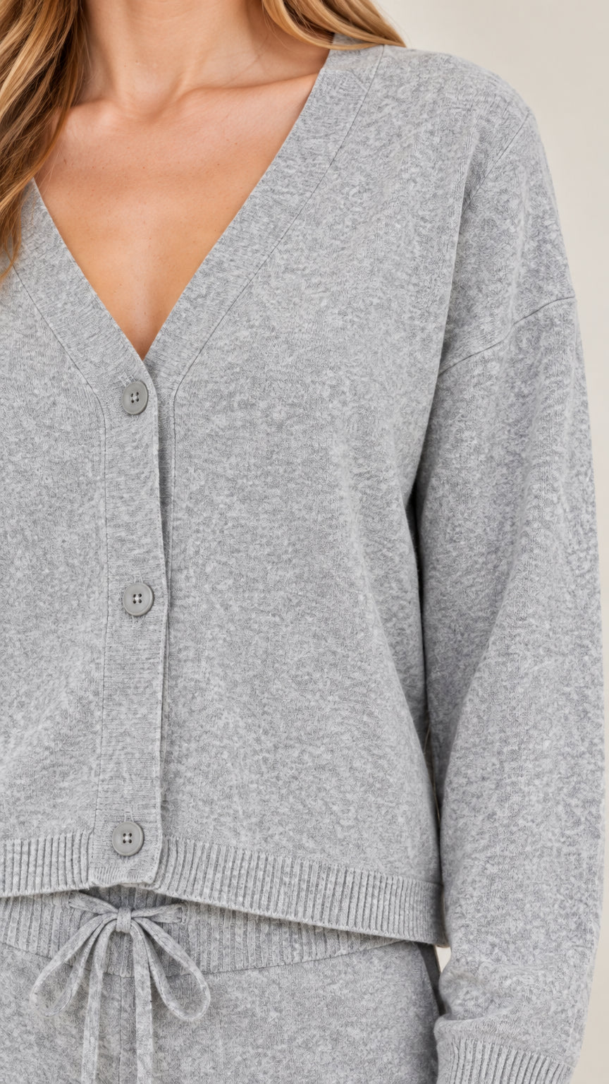 Close-up detail of grey V-neck button cardigan and drawstring waistband