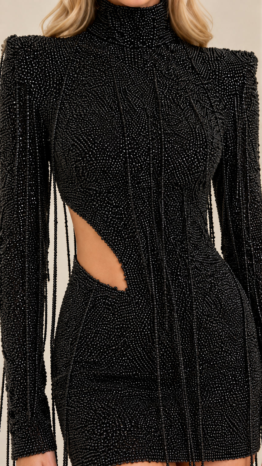 Close-up detail of textured fabric, waist cutout, and bead-like fringe on black dress