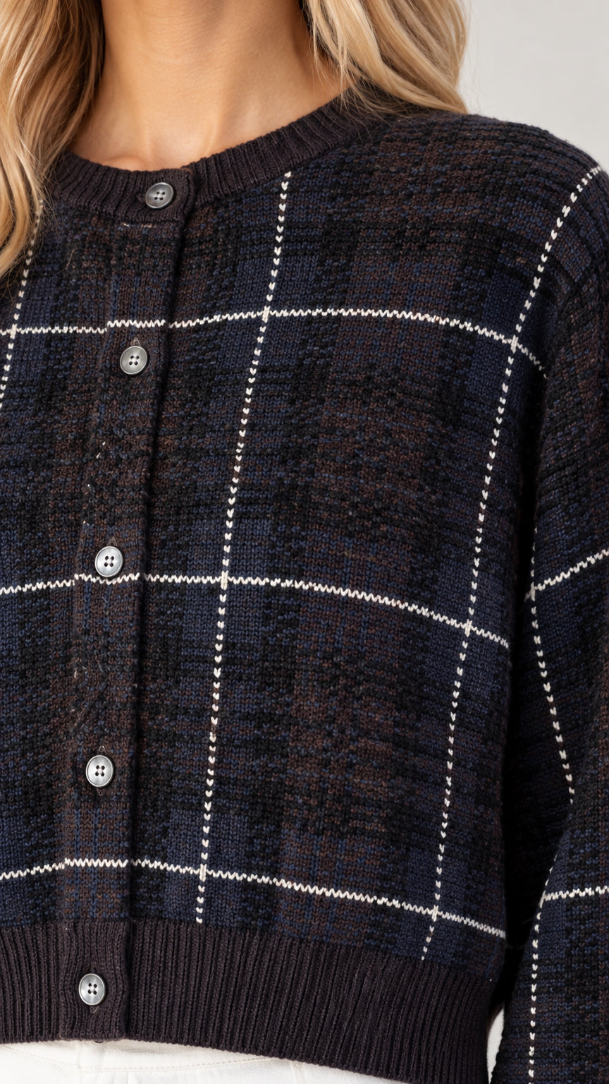 Close-up detail of black plaid knit cropped cardigan with button front and ribbed trim