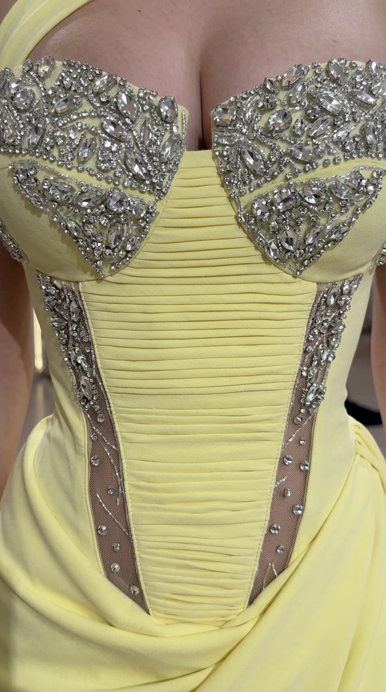 Close-up of rhinestone and crystal embellishments on pleated yellow corset bodice