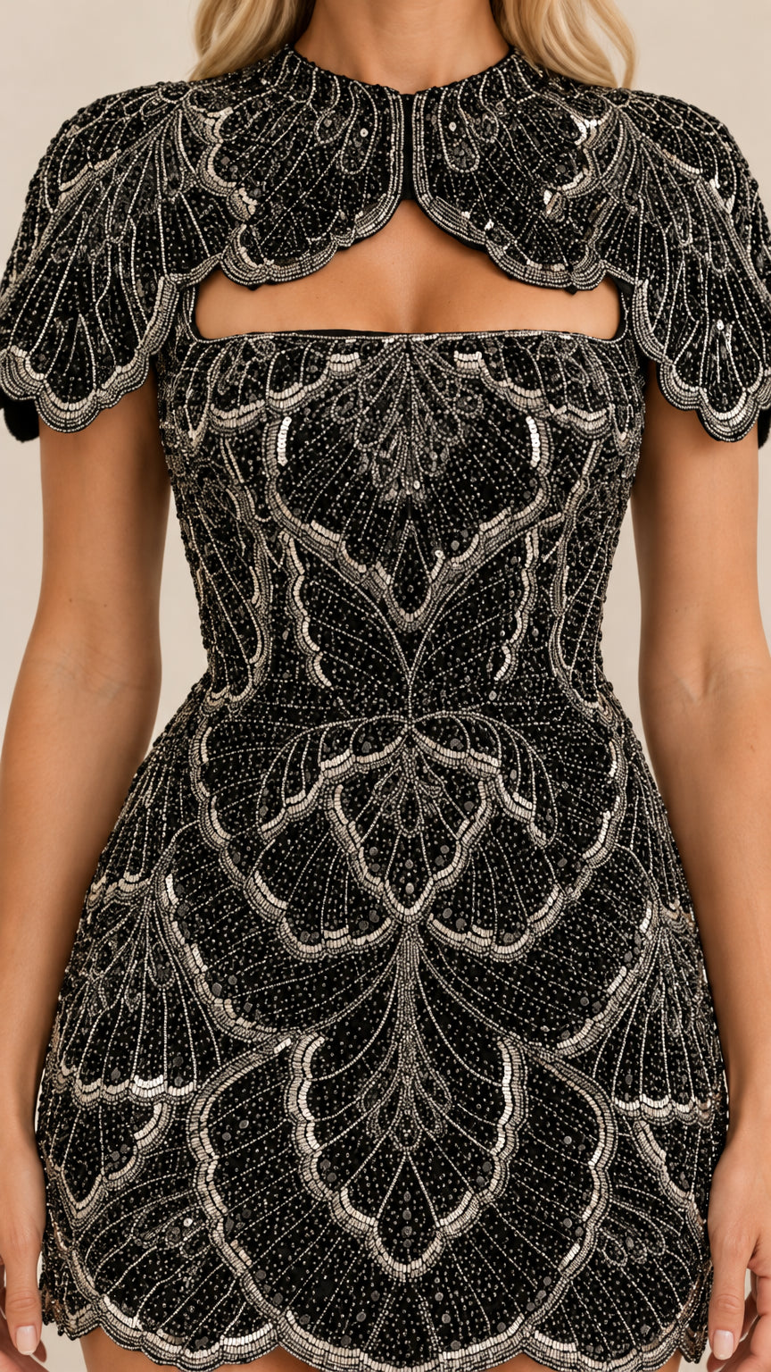 Close-up detail of black fabric with intricate beadwork and cutout neckline