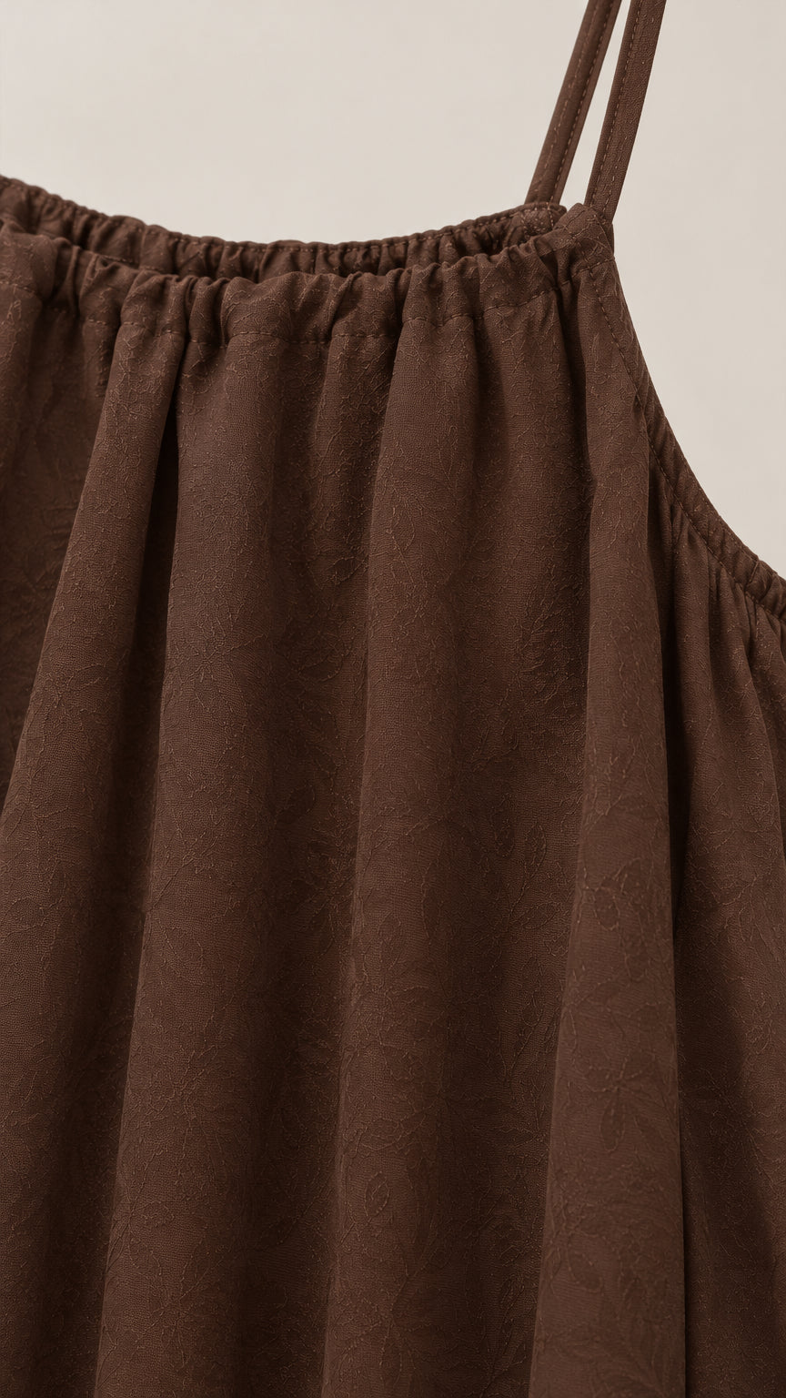 Close-up detail of gathered neckline and textured fabric on brown cami jumpsuit
