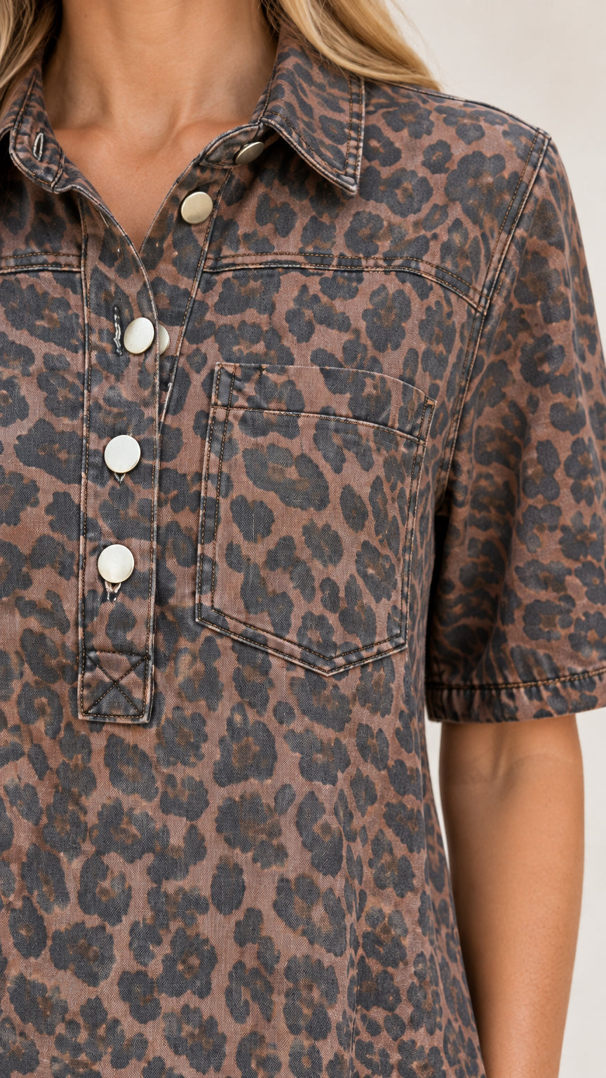 Close-up detail of turn-down collar, metallic button placket, and chest pocket on brown leopard dress