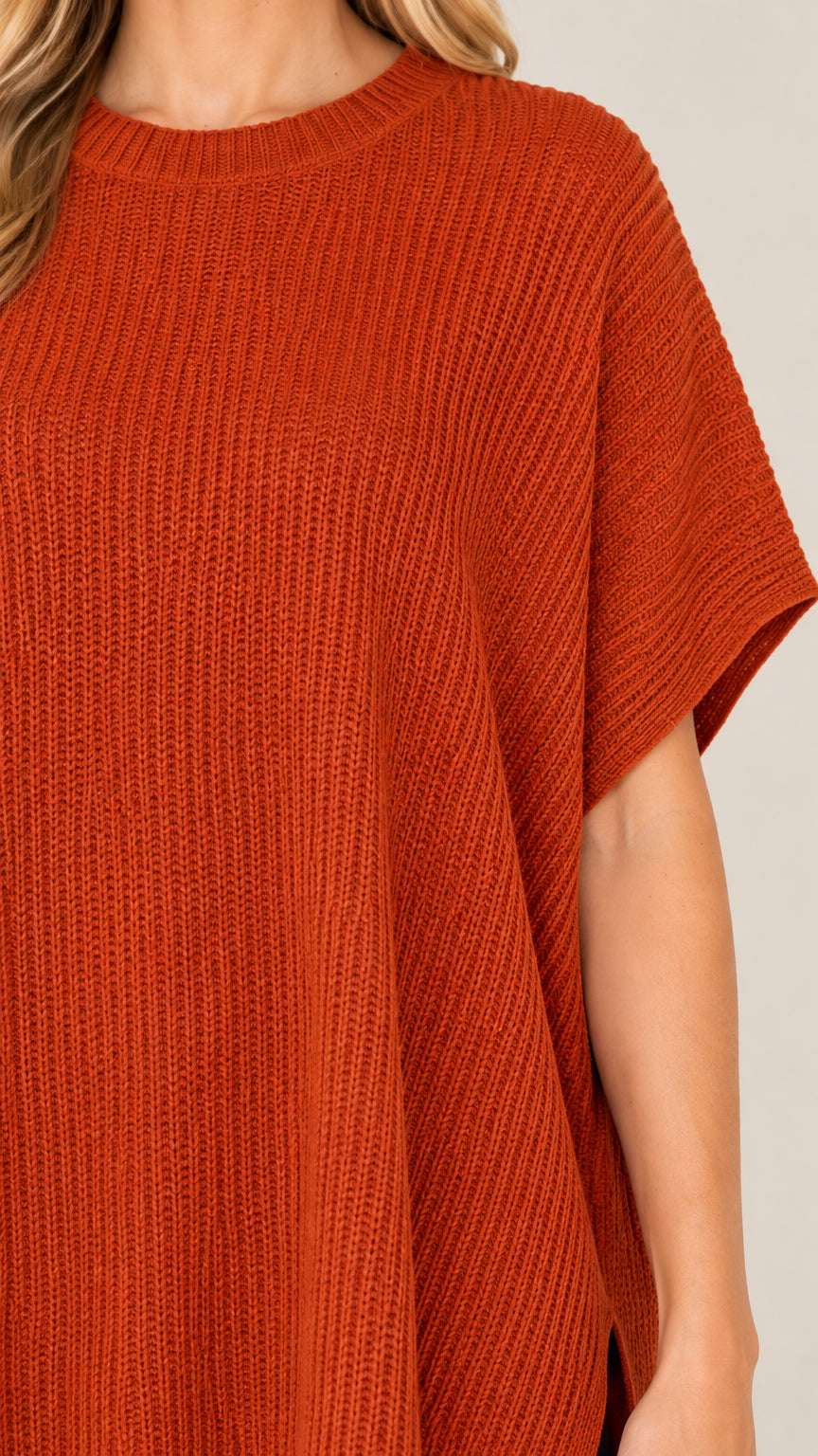 Close-up detail of rust orange ribbed knit texture and crew neckline