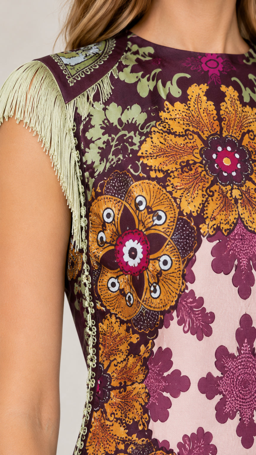 Close-up detail shot of fringe shoulder trim and intricate floral pattern on neckline and chest