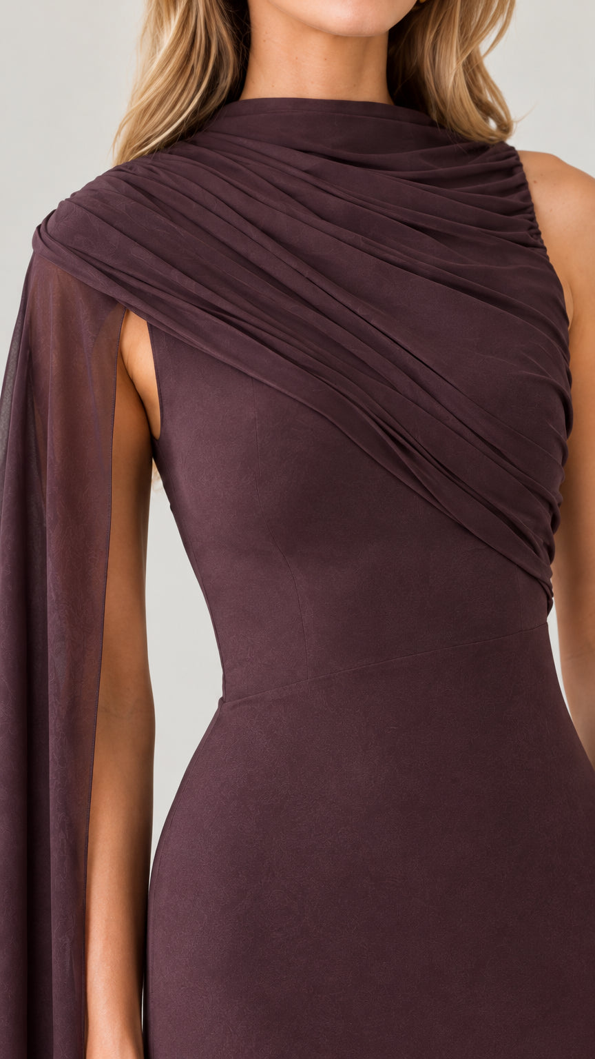 Close-up detail of gathered asymmetrical neckline and draped shoulder cape on plum gown