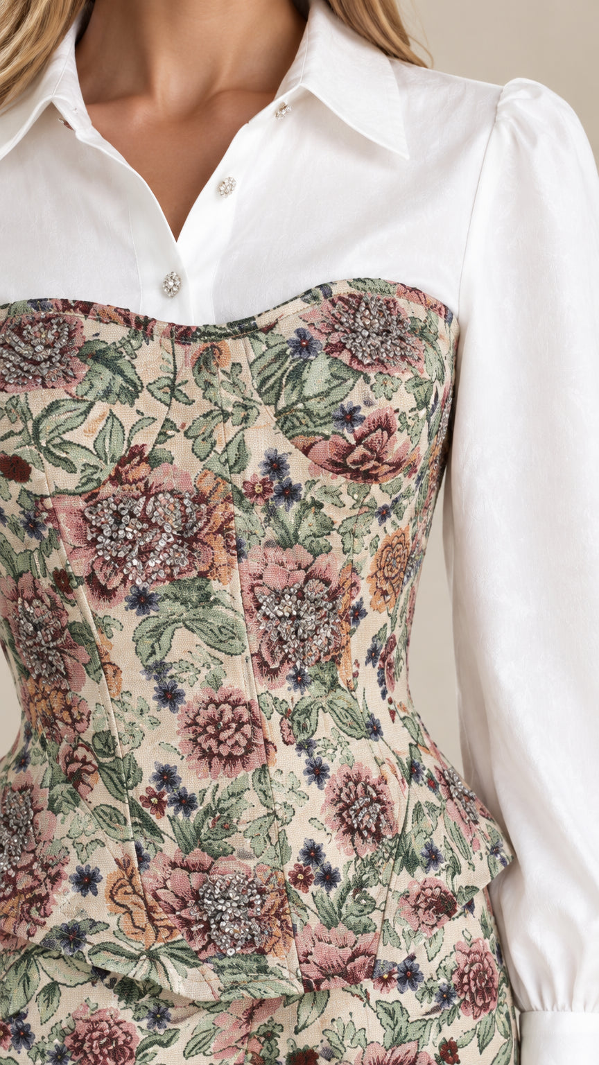 Close-up detail of structured floral tapestry corset top with white collared shirt and jeweled buttons