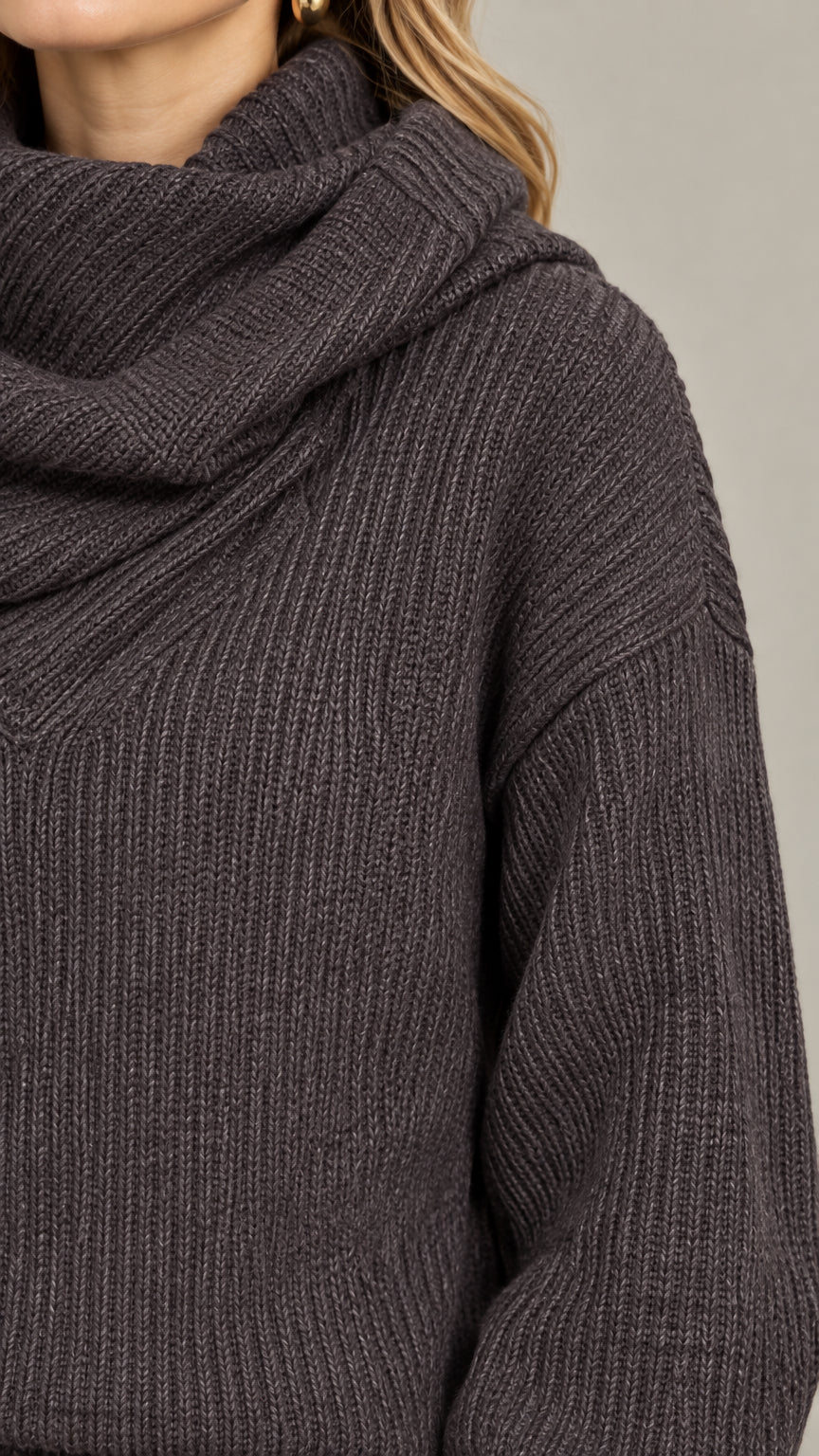 Close-up detail of the charcoal ribbed knit fabric and structured cowl wrap neckline
