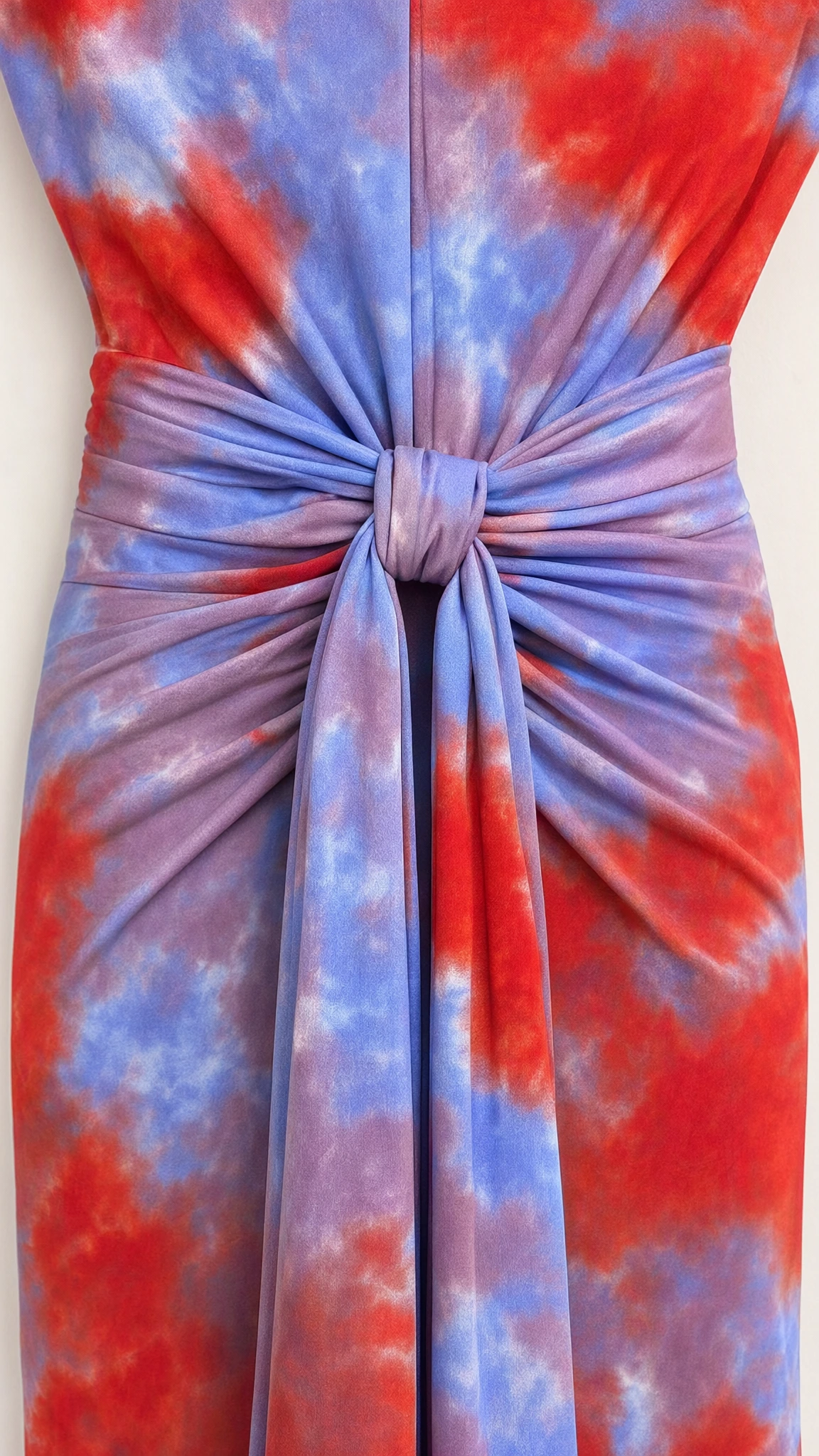 Close-up detail of gathered center knot and vertical draped sash on tie-dye dress