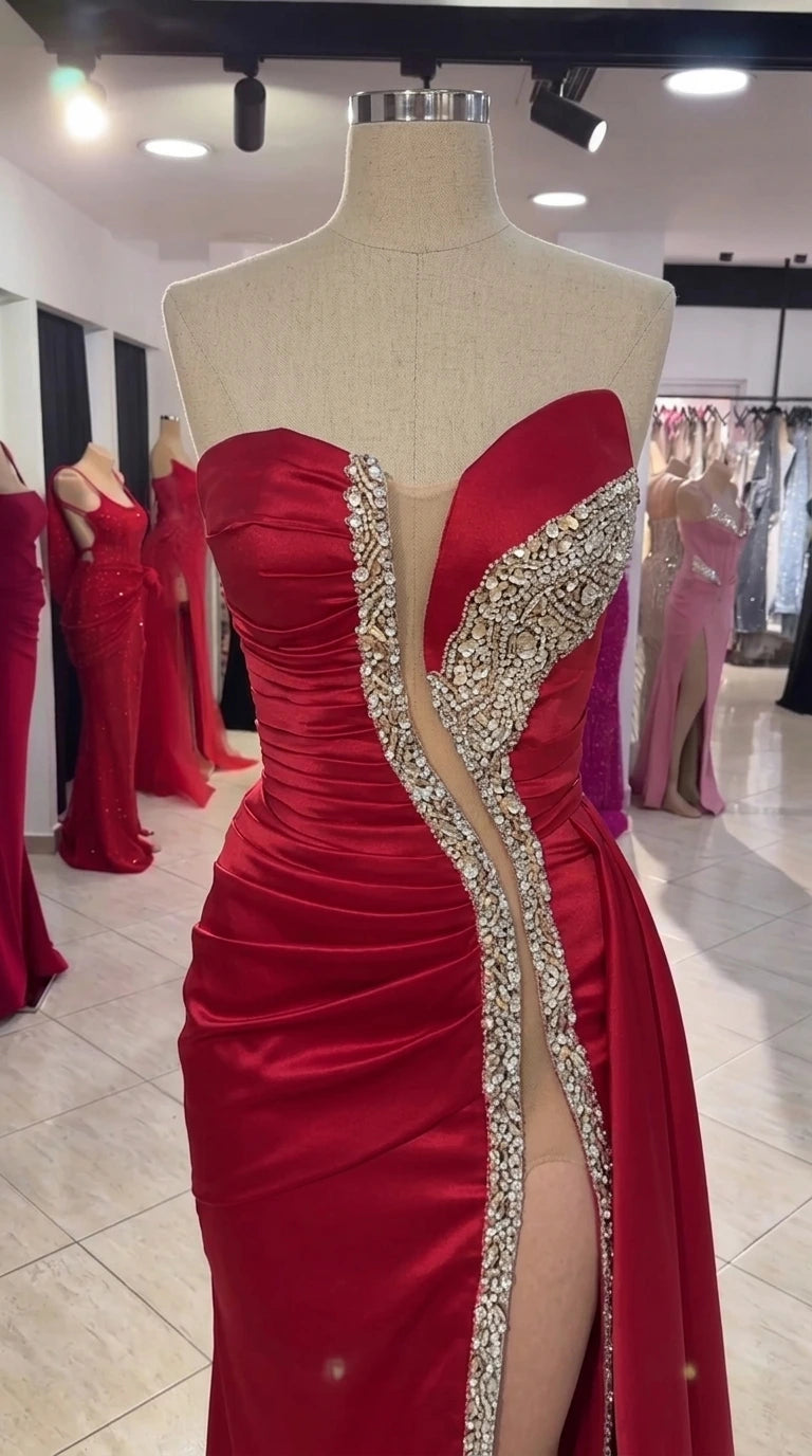 Close-up mannequin display of red satin gown bodice featuring sweetheart neckline, ruching, and rhinestone trim
