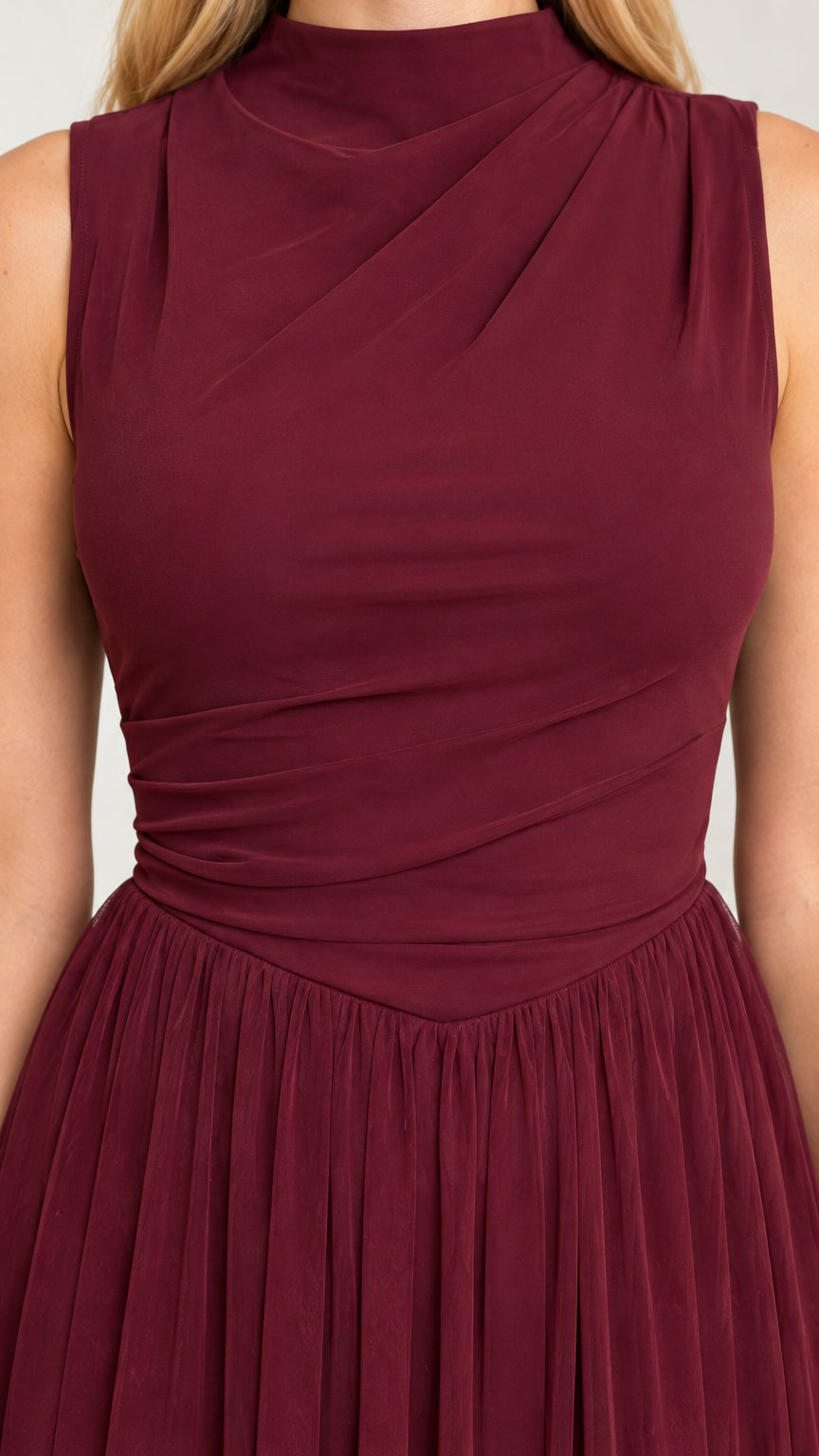 Close-up detail of burgundy ruched mock neck bodice and pleated waistline