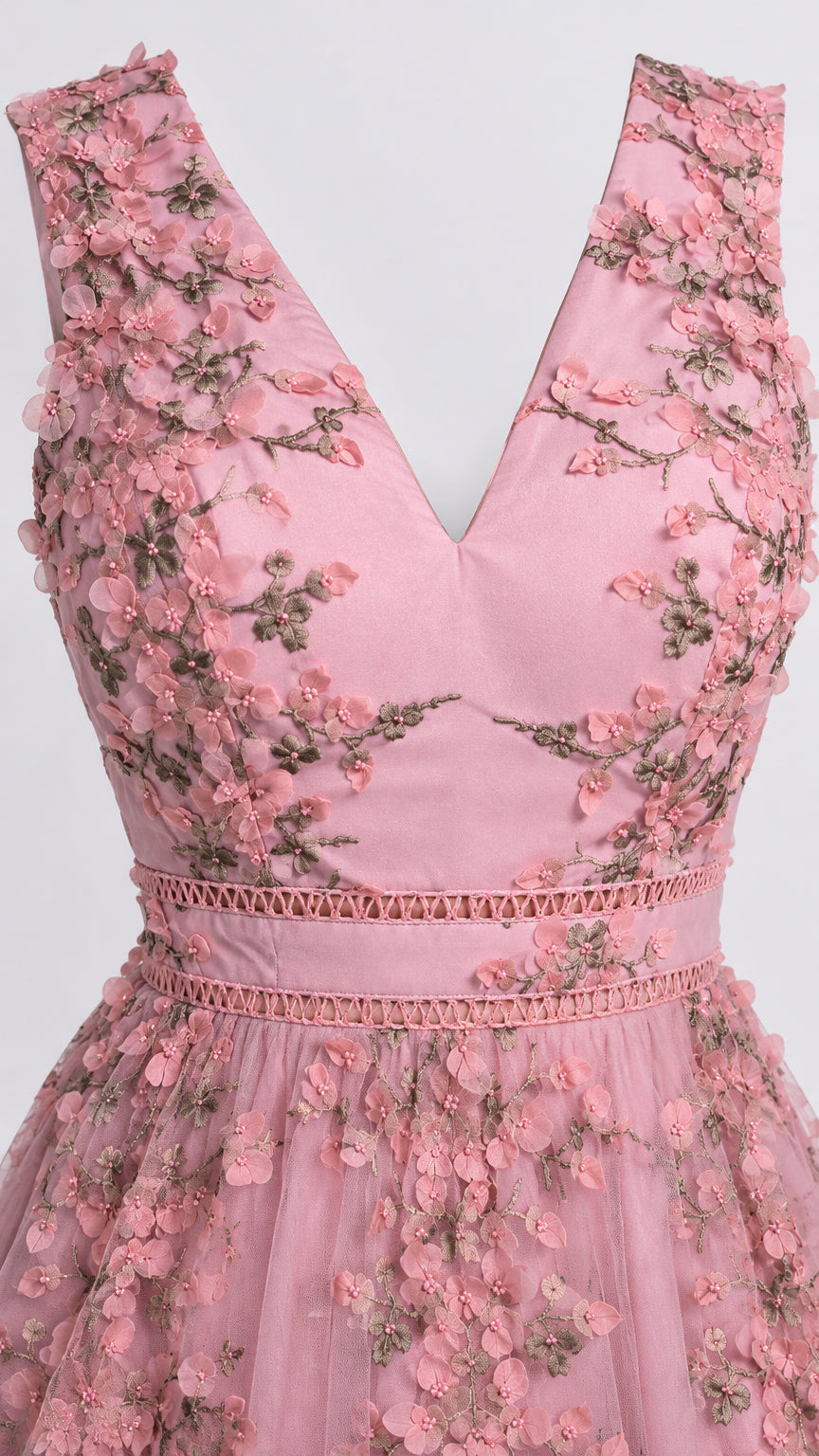 Close-up detail of pink bodice with 3D floral appliqué and waist trim