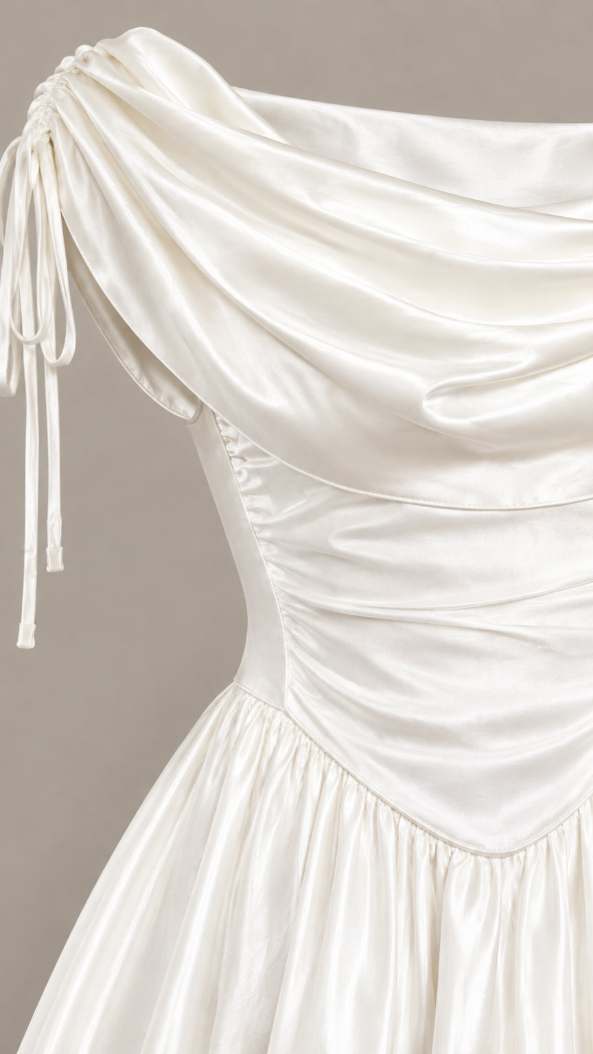 Close-up detail of white satin cowl neckline, shoulder ties, and ruched bodice