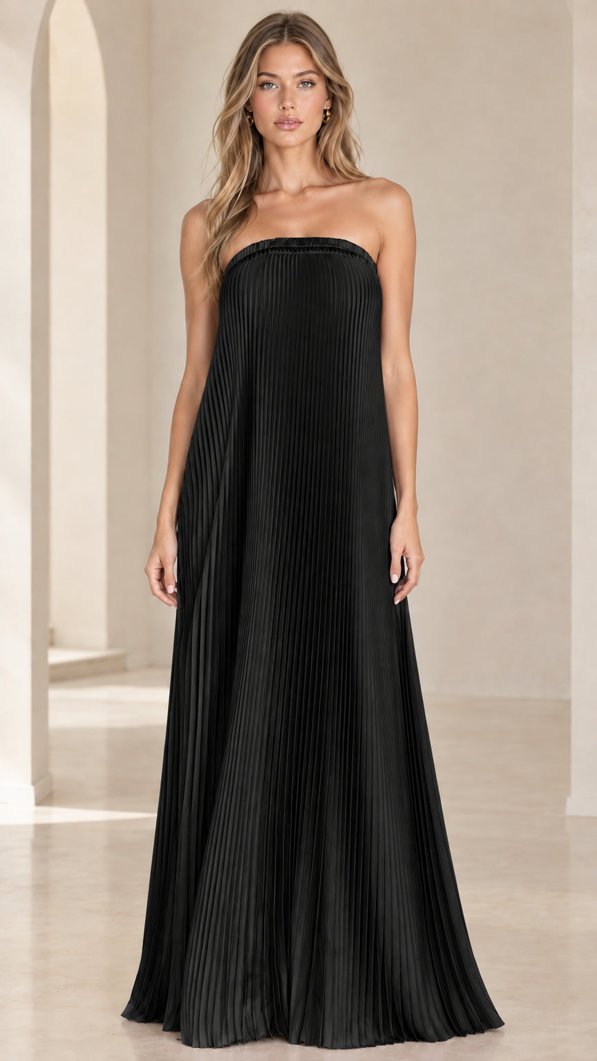 Front view of model wearing a solid black strapless pleated maxi dress