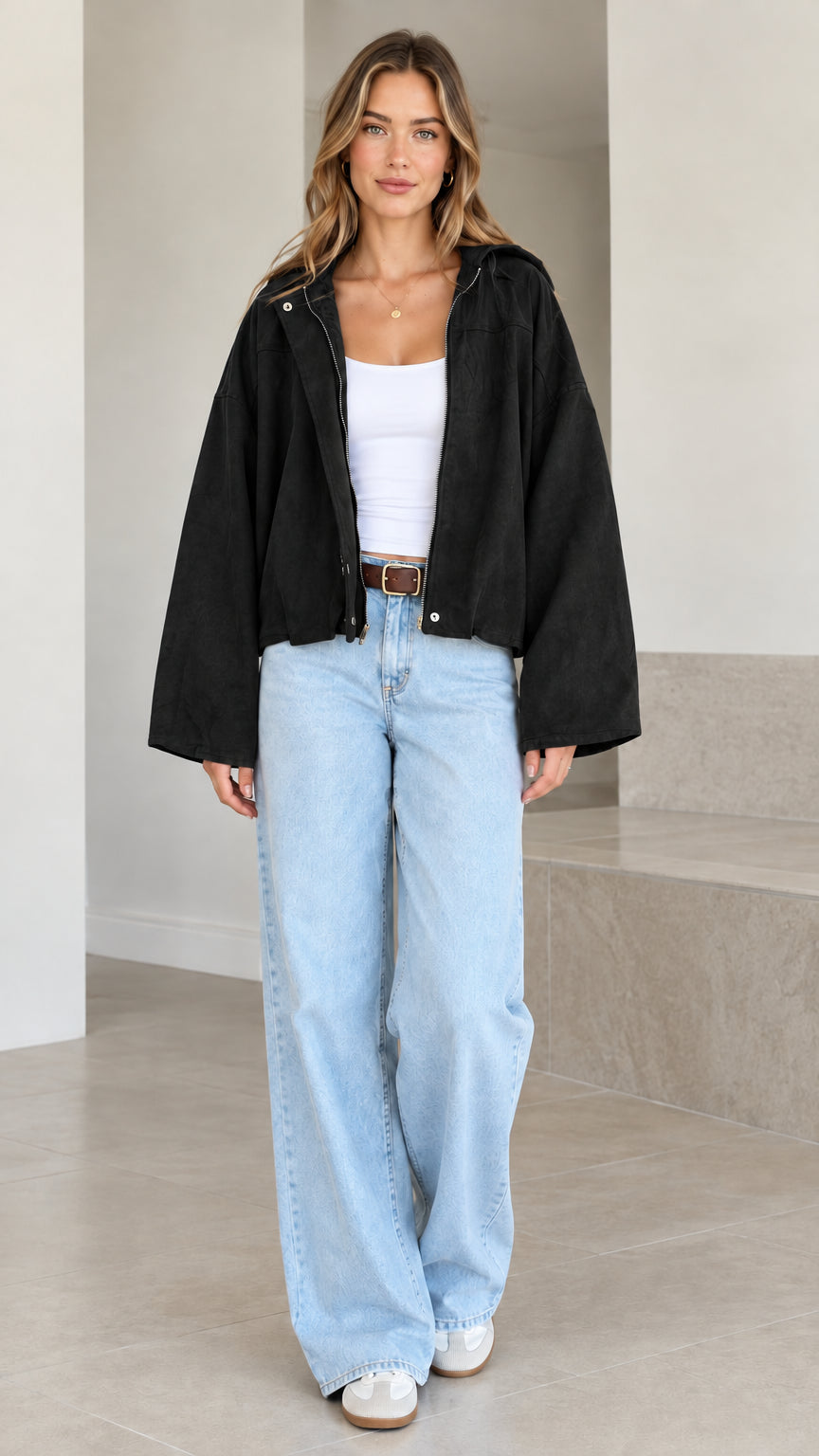 Model wearing black wide-sleeve hooded cropped jacket paired with light blue jeans