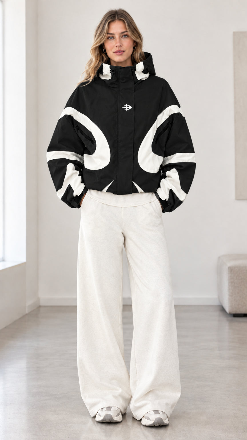 Front view of model wearing black and white colorblock hooded jacket