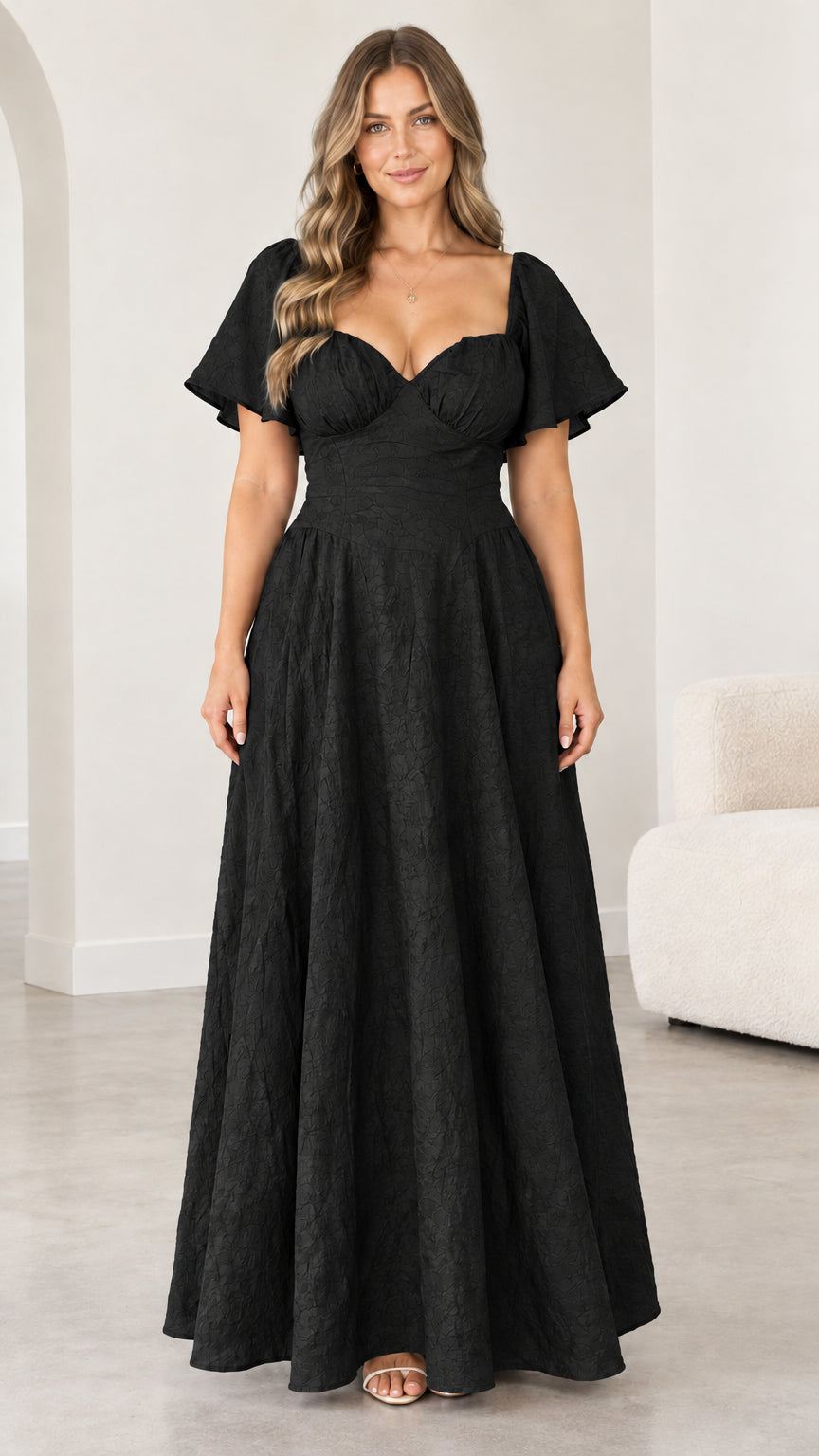 Front view of woman wearing black sweetheart flutter sleeve maxi dress